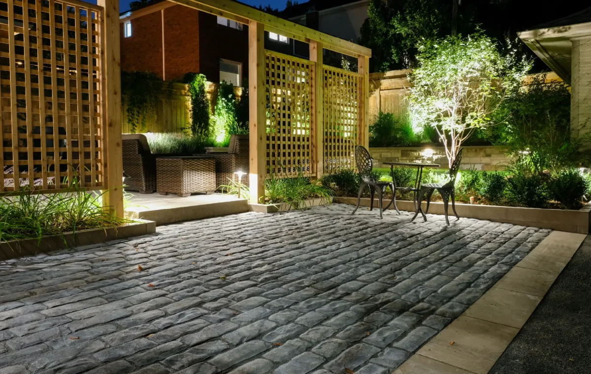 A backyard in Hamilton, Ontario with new patio and retaining wall by Boulder Design Pools and Landscapes