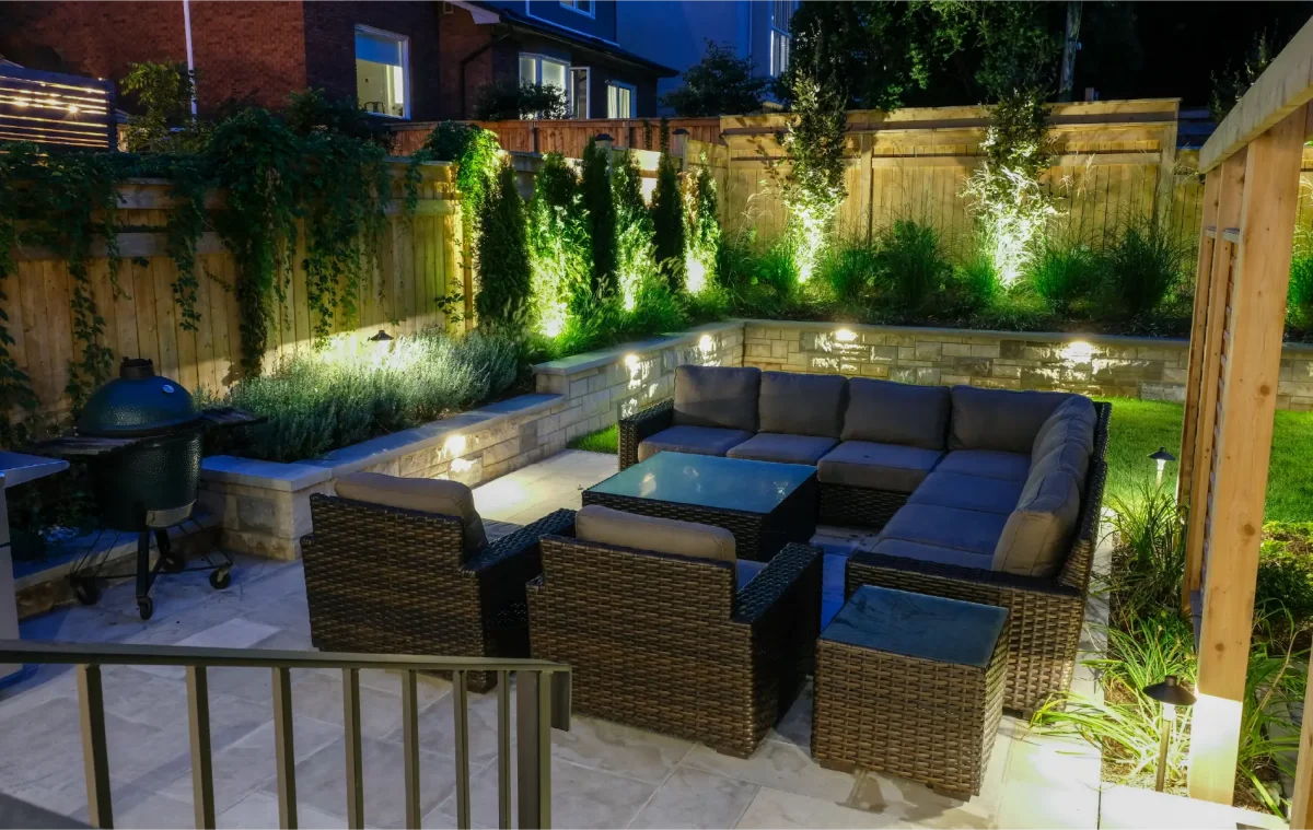 A backyard in Hamilton, Ontario with new patio and retaining wall by Boulder Design Pools and Landscapes