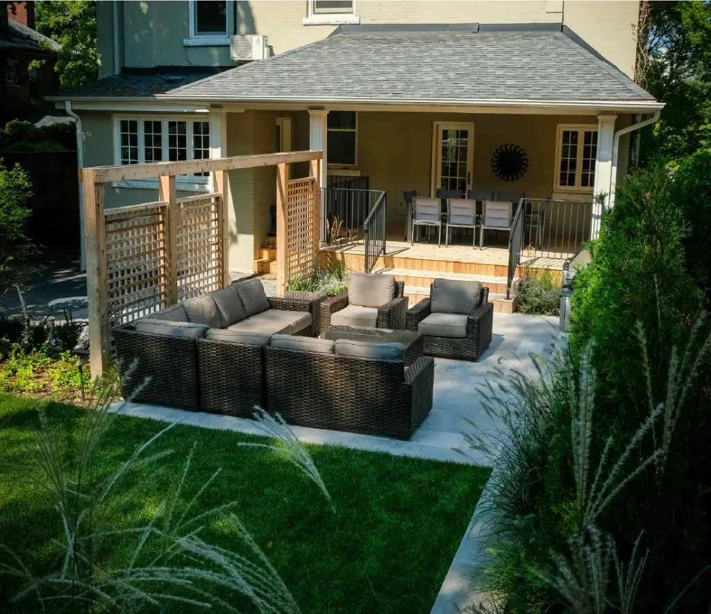 A backyard in Hamilton, Ontario with new patio and retaining wall by Boulder Design Pools and Landscapes