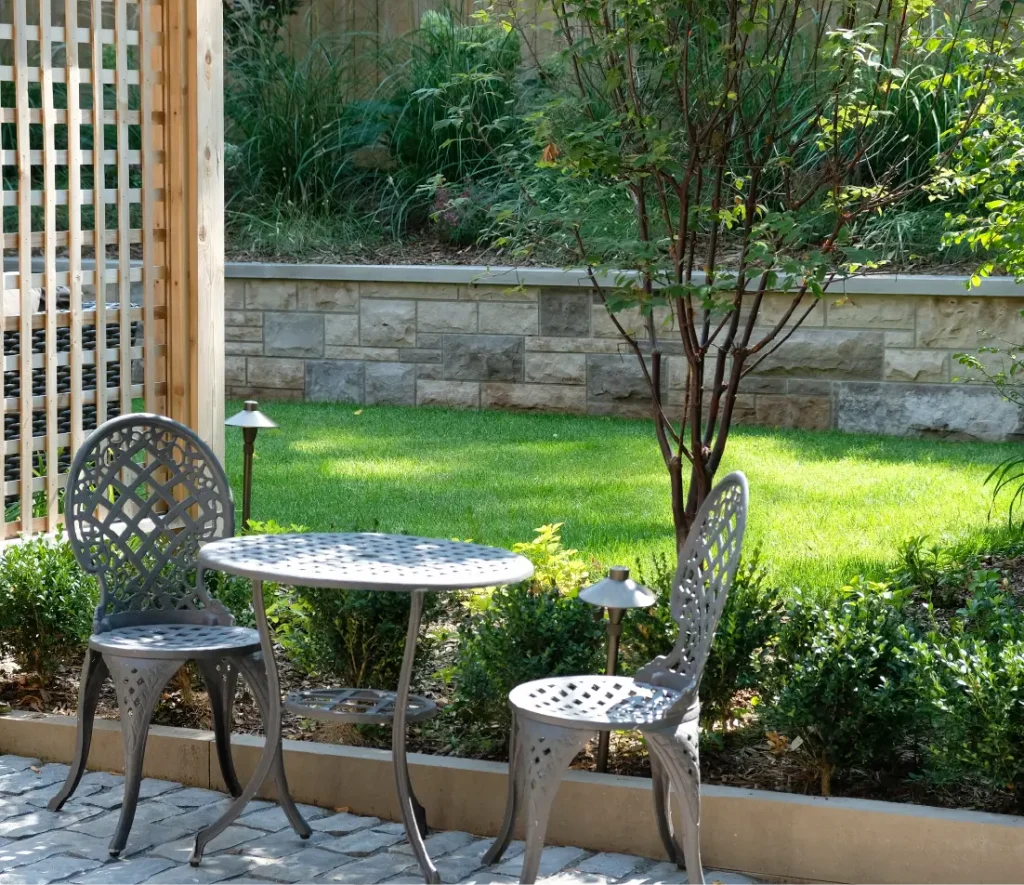 A backyard in Hamilton, Ontario with new patio and retaining wall by Boulder Design Pools and Landscapes