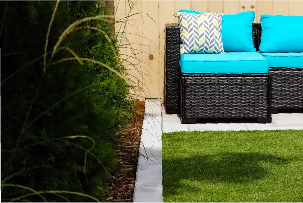 Backyard pool and landscape installation by Boulder Design Pools & Landscapes with pool barrier safety fence, turf grass and waterfall feature